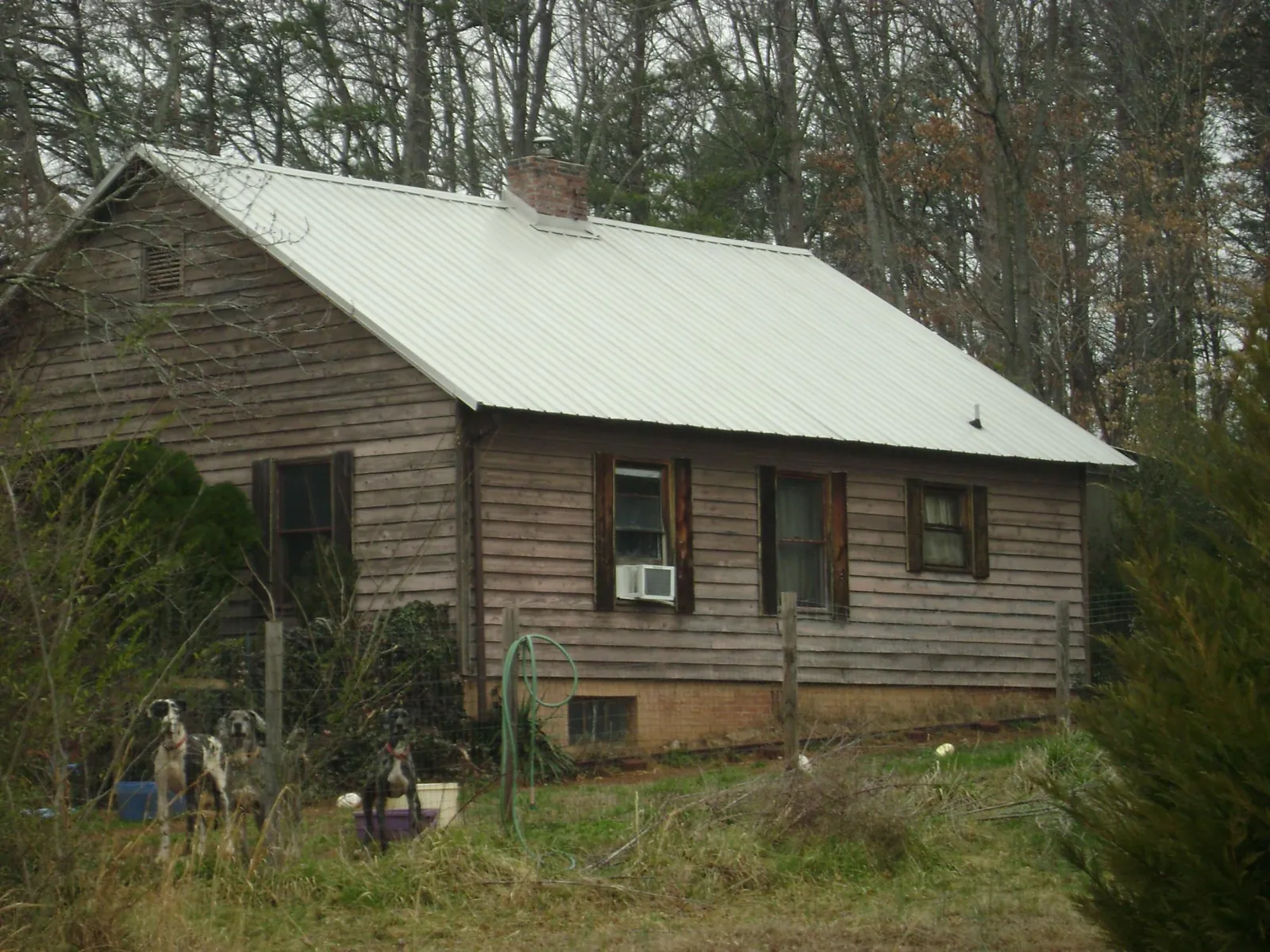 White metal roof on an old wood sided farmhouse, from a Metal Roof Installation job in Almont